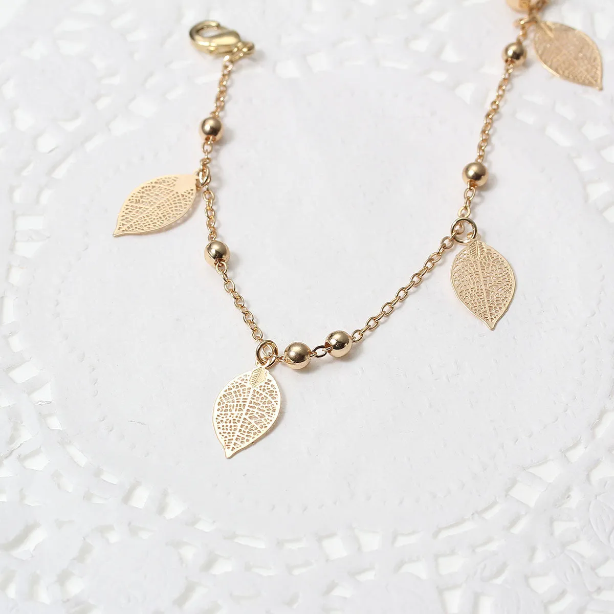 SEXY SPARKLES Filigree Stamping Bell Bracelet  Gold Plated Whit Hollow Leaf Pendants
